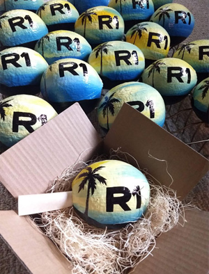 Painted hollow coconuts with scrolled invitation make green and eco-friendly gifts